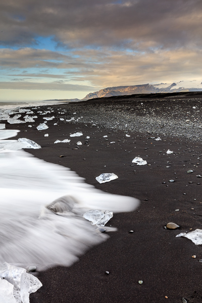 Black volcanic beach at Jökulssarlon with an arm of the Vatnajökull glacier in the background