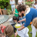 Eric is blowing out the candles while Genevieve and Mama are overseeing it all.