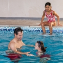 Mikee is looking at Tim Ford teaching Lara how to swim
