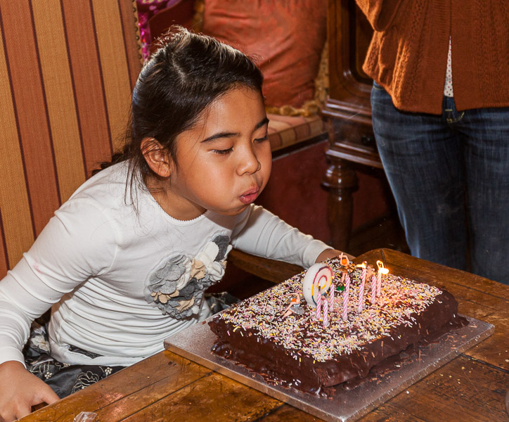 Mikee is blowing out the cake