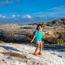 Mikee in the middle of the foam that has blown up on the rocks