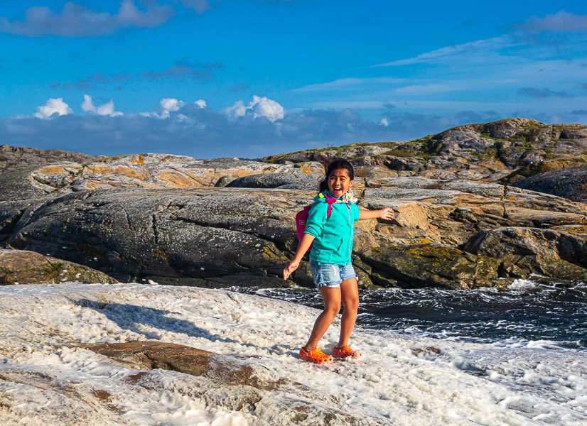 Mikee in the middle of the foam that has blown up on the rocks